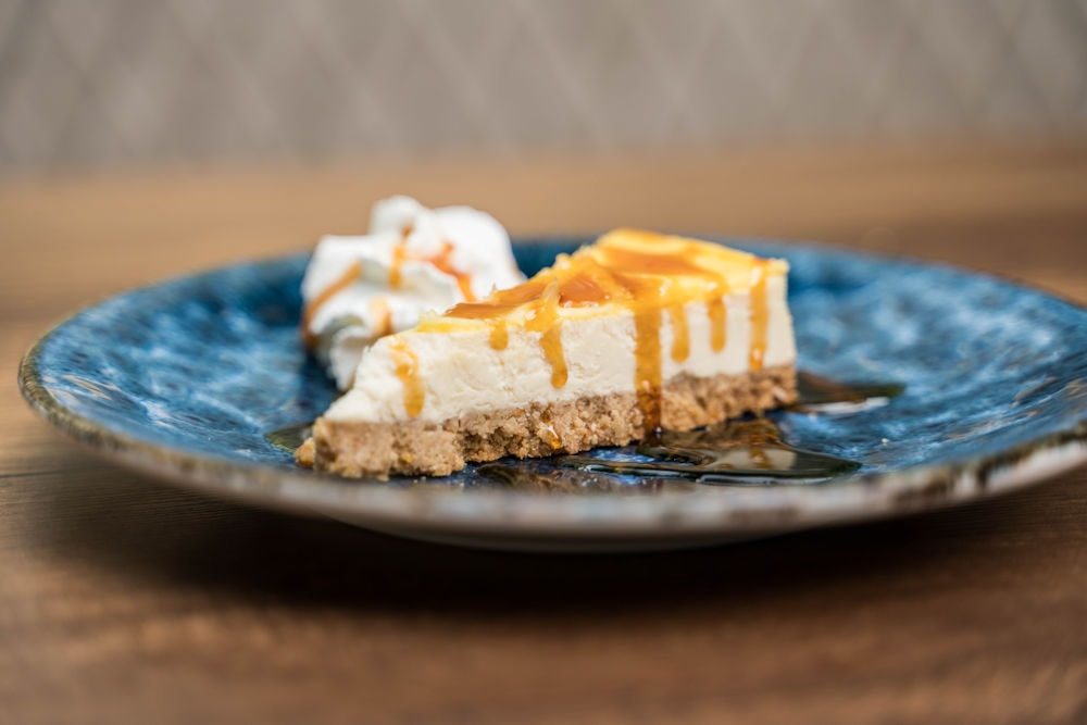 Cheesecake slice with caramel drizzle and cream